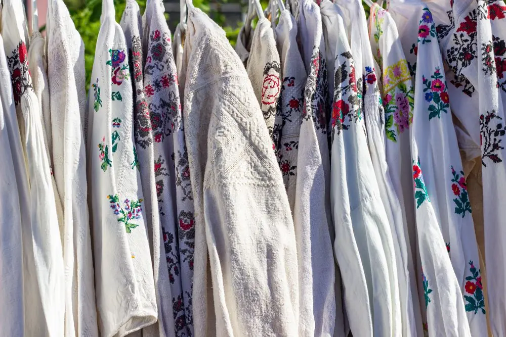Reference photo 4: embroidered white kurtas and tops on hangers — kurtis we manufacture and export in bulk