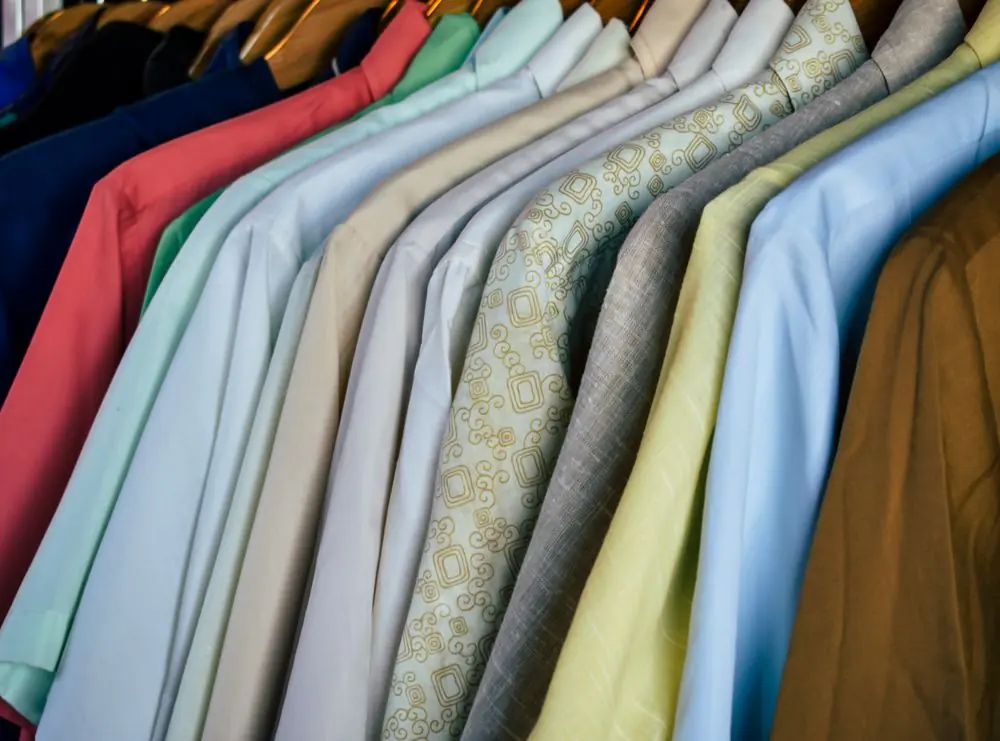 Reference photo 3: polo shirts in many colours on wooden hangers — polo t-shirts we manufacture and export in bulk to Qatar