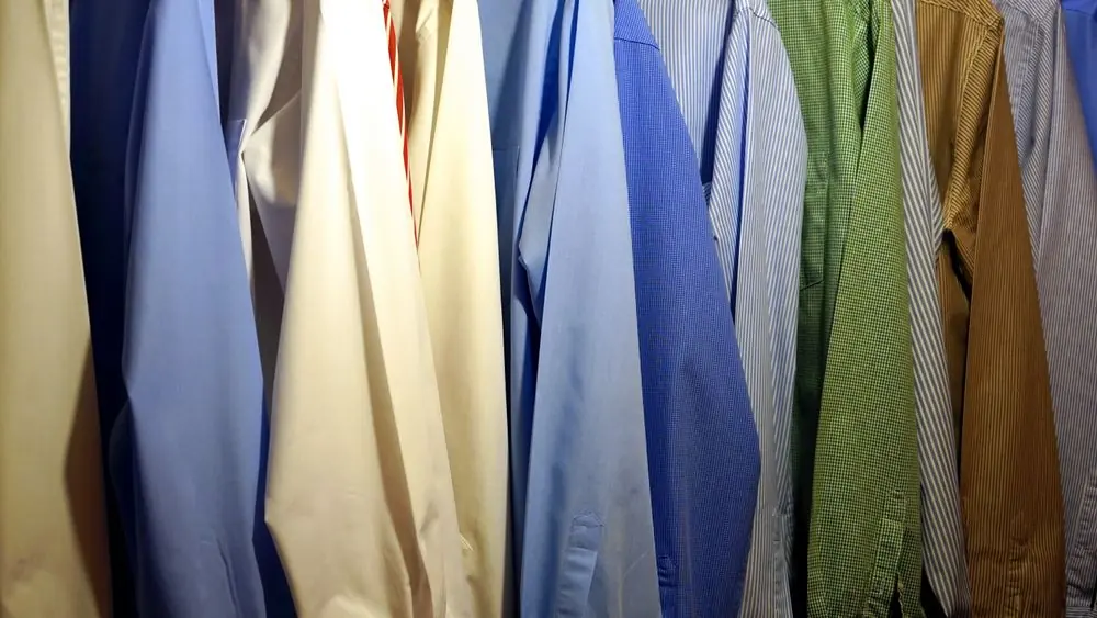 Reference photo 2: dress shirts in blue, cream and green hanging in a row — shirts we manufacture and export in bulk
