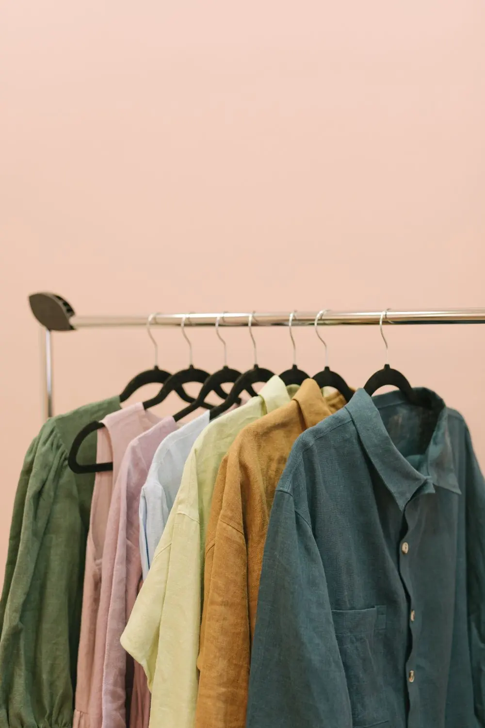 Reference photo 3: casual shirts on a rail against a peach wall — shirts we manufacture and export in bulk