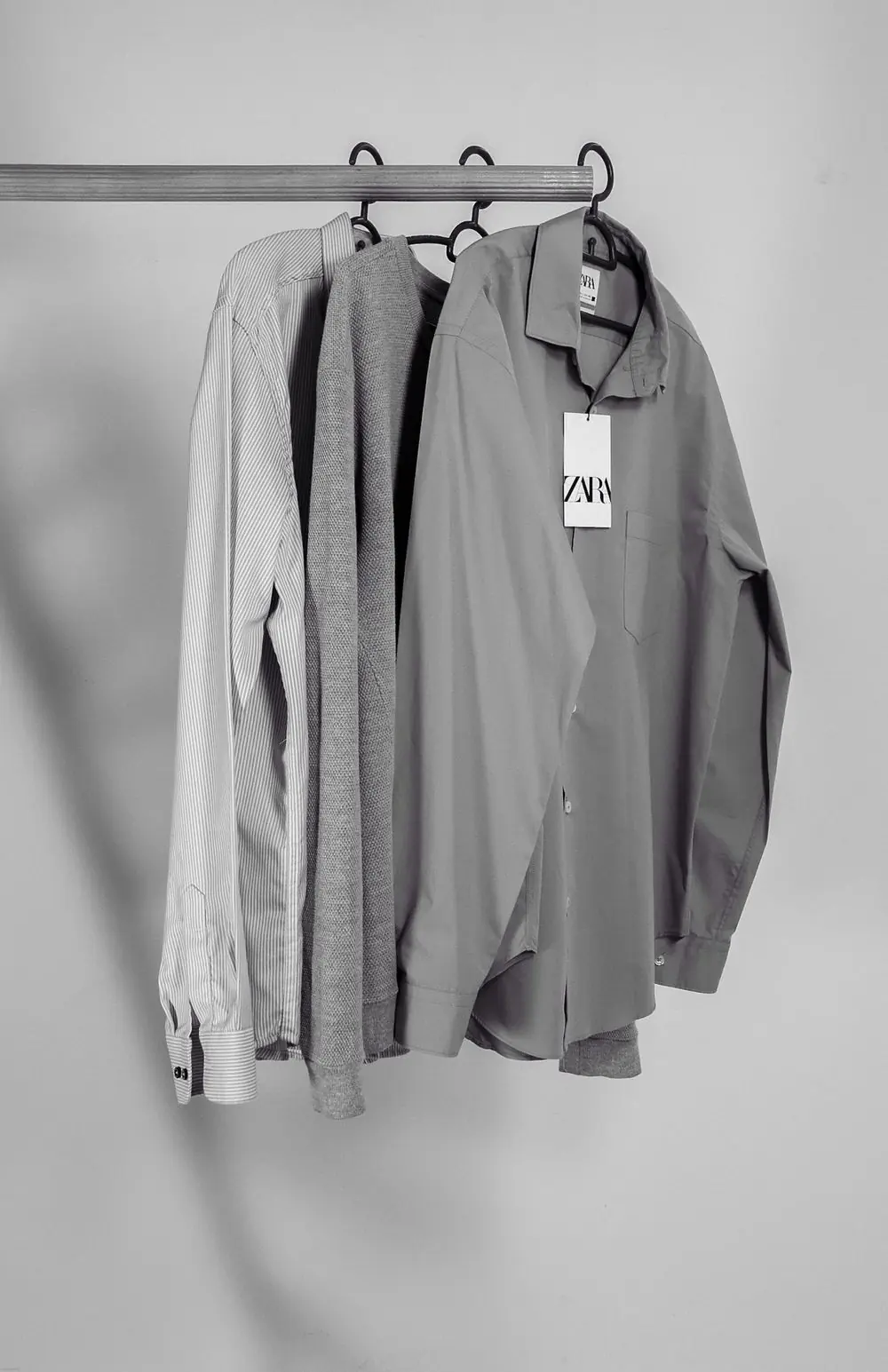 Reference photo 4: grey long-sleeve shirts hanging on a rail — shirts we manufacture and export in bulk