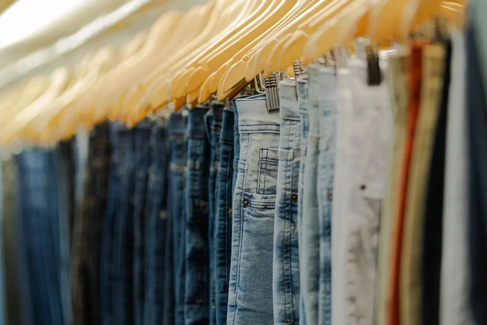 Reference photo 3: rows of trousers on wooden hangers — trousers & cargo pants we manufacture and export in bulk to Saudi Arabia