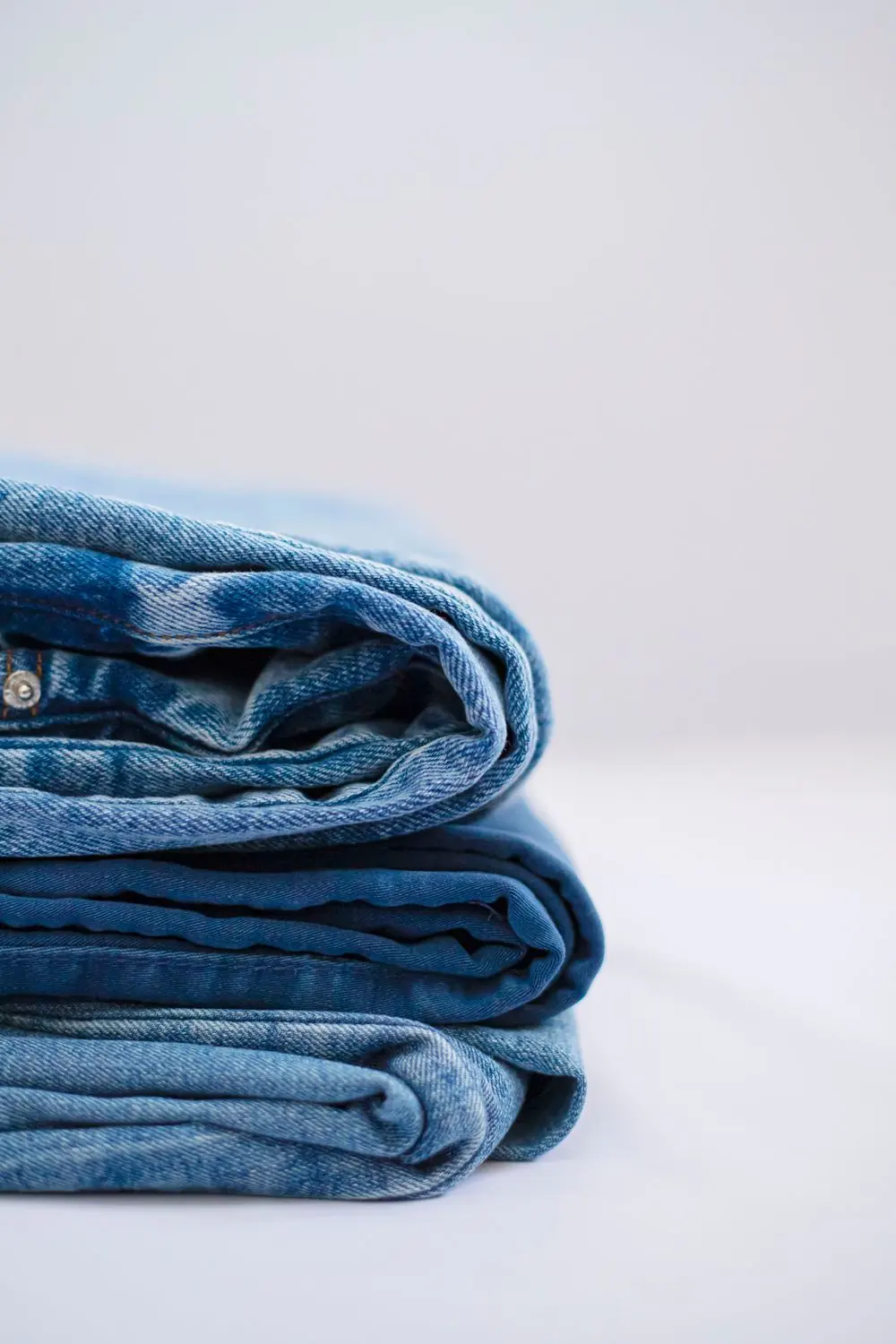 Reference photo 4: folded denim trousers in a stack — trousers & cargo pants we manufacture and export in bulk to Saudi Arabia